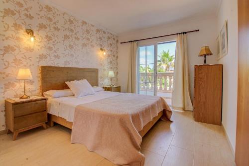 um quarto com uma cama e uma grande janela em Can Caldero by Rentallorca em Llucmajor