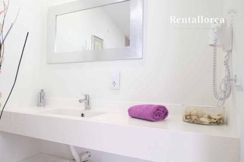 a bathroom sink with a purple towel and a mirror at Finca es Collet by Rentallorca in Manacor