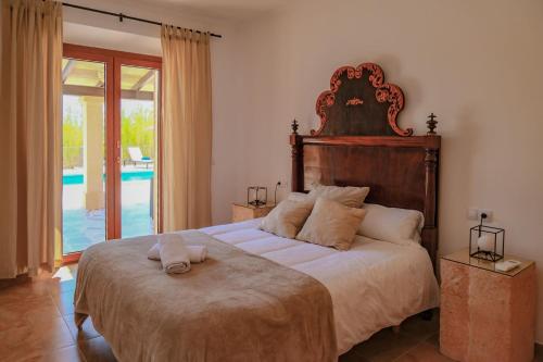a bedroom with a large bed and a pool at Finca Son Roca by Rentallorca in Montuiri