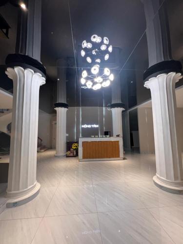 a large room with columns and a stage with a chandelier at Hồng Tâm Hotel in Da Lat