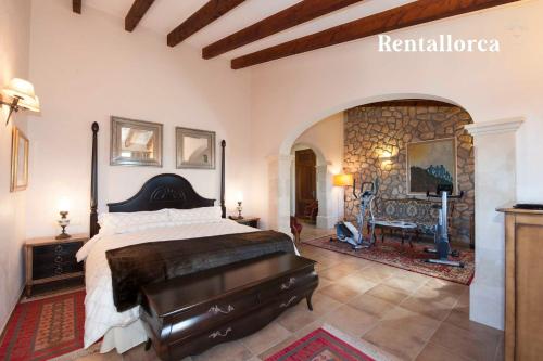 1 dormitorio con cama y pared de piedra en Finca Can Corem by Rentallorca en Manacor