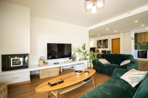 a living room with a green couch and a table at Postcard View @ Coimbra Downtown in Coimbra