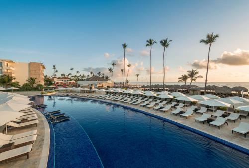 a pool with lounge chairs and umbrellas at a resort at Royalton Bavaro, An Autograph Collection All-Inclusive Resort & Casino in Punta Cana