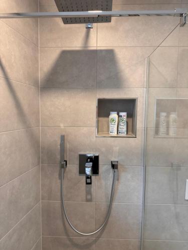 um chuveiro com uma porta de vidro com duas escovas de dentes em FeWo KU28 One em Bamberg