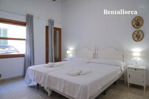 una camera da letto con un letto bianco con due asciugamani di Casa Ca mado Josefa by Rentallorca a Santa Margarita