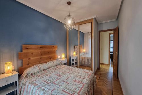 a bedroom with a large bed and a mirror at Apartamento Saavedra in Posada de Llanes