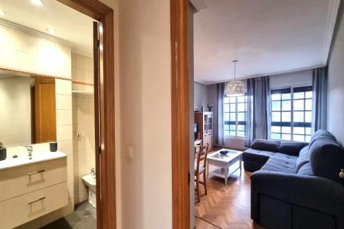 a living room with a blue couch and a kitchen at Apartamento Saavedra in Posada de Llanes