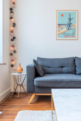 un salon avec un canapé bleu et une table dans l'établissement Lille Centre apartment with character, à Lille
