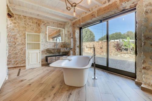 a large bathroom with a tub and a large window at Villa Petit Bijoux by Rentallorca in Can Picafort