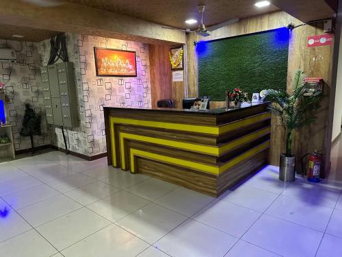a bar in a restaurant with yellow and black stripes at Hotel New Shiv Kunj in Vadodara