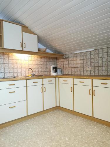 Sand in TaufersにあるApartments Steger Sand in Taufers Campo Turesのタイル張りのキッチン(白いキャビネット付)