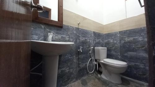 La salle de bains est pourvue d'un lavabo et de toilettes. dans l'établissement Sewana Guest INN, à Wellawaya