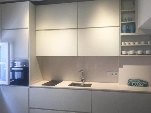 uma cozinha com armários brancos e um lavatório em Sa Caseta by Rentallorca em Sóller