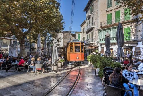 um trem laranja está nos trilhos em uma cidade em Sa Caseta by Rentallorca em Sóller