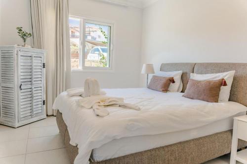 a bedroom with a large white bed and a window at Big apartment in Sea Magic in Kyrenia
