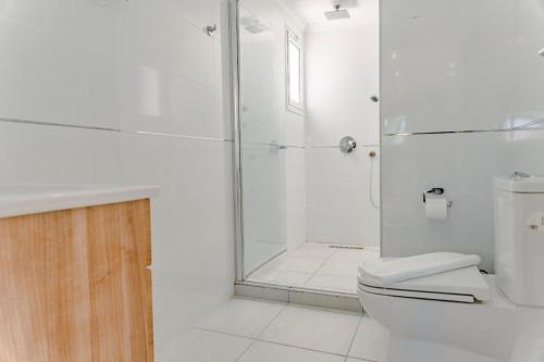 a white bathroom with a shower and a toilet at Big apartment in Sea Magic in Kyrenia