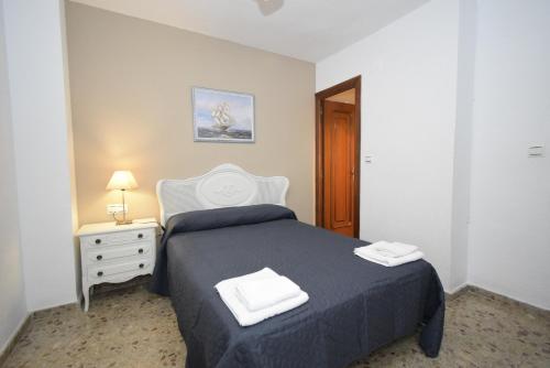 a bedroom with a bed with two towels on it at SAN PEDRO 2 - Fincas Arena in Benidorm