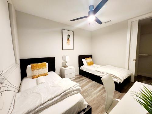 a bedroom with two beds and a ceiling fan at Lux property great for 1 to 8 Guests-family trip ,5Beds 2Rooms Staycation with Gym and EV, proximity to Downtown and Beaches in West Palm Beach