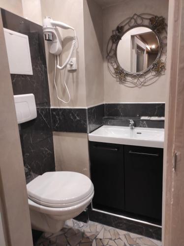 une salle de bain avec toilettes, lavabo et miroir dans l'établissement Hotel Clermont Montmartre, à Paris