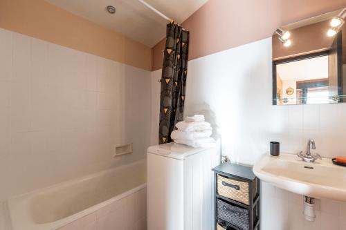 a bathroom with a sink and a white refrigerator at Le petit Schuss - A 10min des remontées mécaniques in La Giettaz