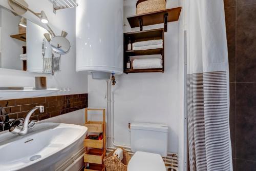 une salle de bain avec un lavabo blanc et des toilettes dans l'établissement La Maison des Bois - Avec Parking Privé, à Manigod