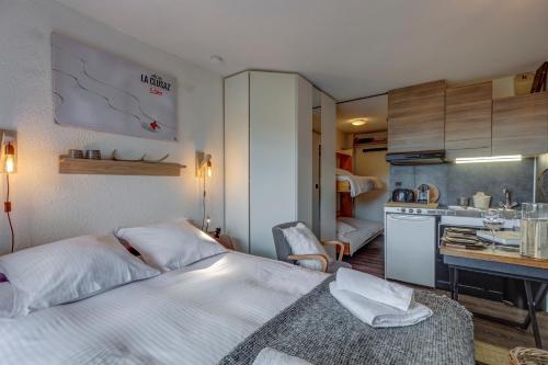 une chambre d'hôtel avec un lit et une cuisine dans l'établissement La Maison des Bois - Avec Parking Privé, à Manigod