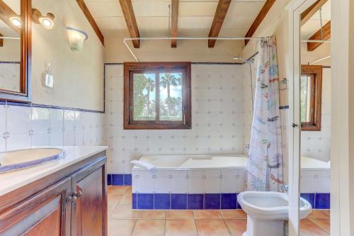 a bathroom with a tub and a toilet and a sink at S'Albufereta by Rentallorca in Alcudia
