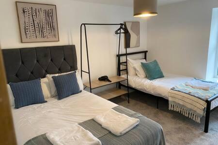 a living room with two beds and a lamp at Forest Loft by Afan Valley Escapes in Port Talbot