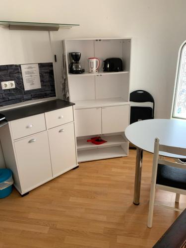 a kitchen with white cabinets and a table at Lagos Room Booking in Lagos