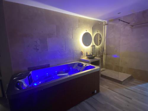 a large blue tub in a bathroom with a mirror at Côté spa in Saint-Victoret