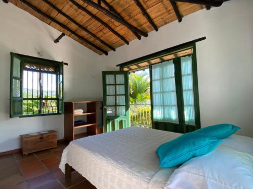 a bedroom with a bed and two windows at Santa Lucia Estancia Rural in Guaduas