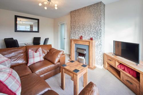 a living room with a couch and a fireplace at Host & Stay - Spring Gardens in Cayton