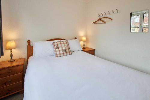 a bedroom with a large white bed and two night stands at Host & Stay - Spring Gardens in Cayton