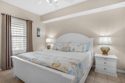 1 dormitorio con cama blanca y ventana en Majestic Sun 806B, en Destin
