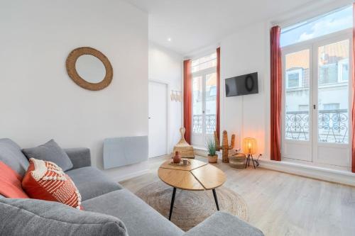 un salon avec un canapé et une table dans l'établissement Lille Centre comfortable, equipped apartment!, à Lille