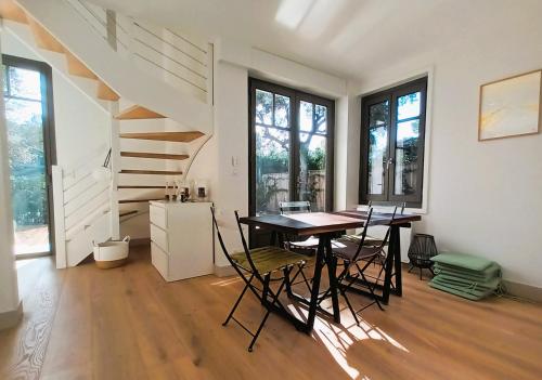 une salle à manger avec une table et des chaises et des escaliers dans l'établissement Arcachon le Moulleau maison moderne 3 chambres climatisation - 250m de la plage, à La Teste-de-Buch
