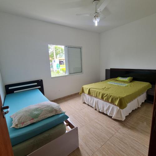 a bedroom with two beds and a window at Casa em condomínio Ninho Verde 1 in Porangaba