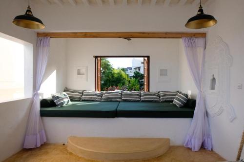 duże zielone łóżko w pokoju z oknem w obiekcie Shela Bahari w mieście Shela