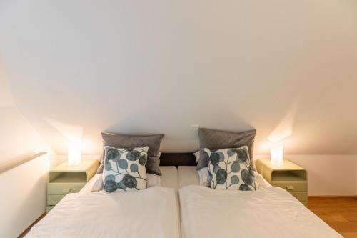 two beds in a small room with two lamps at Andrea in Aventoft