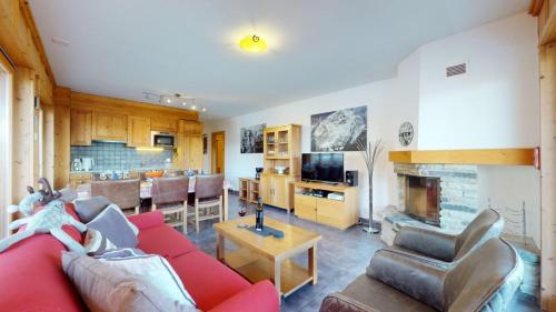 a living room with a red couch and a fireplace at Hauts de Veysonnaz SAUNA & VIEW apartments in Veysonnaz