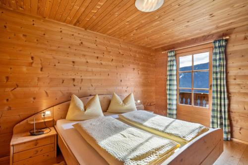 a bedroom with a bed in a wooden room at Thalhof Hochwart in Ultimo