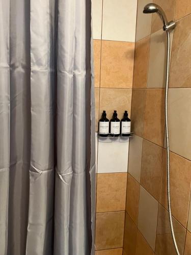 a shower with three bottles of whiskey on a shelf at Chalupa na Lípové v Hlohovci in Hlohovec