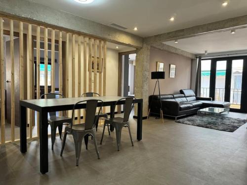 uma sala de estar com uma mesa e cadeiras e um sofá em Elegante piso reformado a 1km del centro em Granada