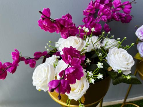 a vase filled with purple and white flowers at Beautiful 1 BHK in Dehradun in Dehradun