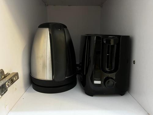 a coffee maker and a toaster sitting next to each other at Beautiful 1 BHK in Dehradun in Dehradun