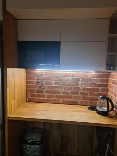 a wooden shelf with a brick wall behind it at Apartament 3 pokoje in Słupsk