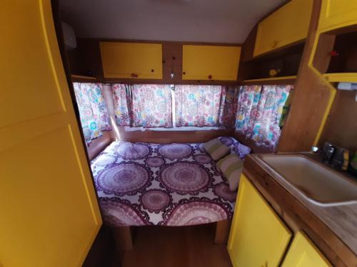 um pequeno quarto com uma cama na parte de trás de uma caravana em Maestrat Park Static Homes, Motorhomes, Caravans & Tents em Sant Jordi