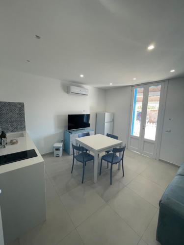 eine Küche und ein Wohnzimmer mit einem Tisch und Stühlen in der Unterkunft A due passi dal mare in Granitola