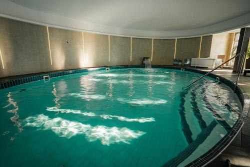 une grande piscine d'eau dans un bâtiment dans l'établissement Šport Hotel *** Donovaly, à Donovaly