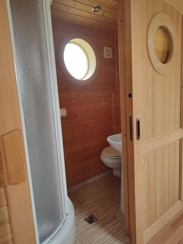 a small bathroom with a toilet and a window at Roulotte équipée - Gite La Pâquerie in Le Louroux-Béconnais